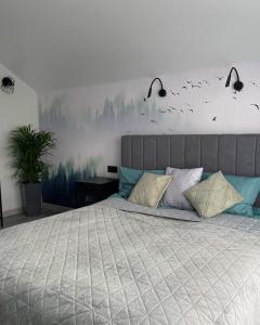 a bedroom with a large bed with birds on the wall at MoonLight in Slavske