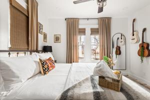 a bedroom with a large white bed with a basket on the floor at Southbound Stays - Country Cottage in Nashville