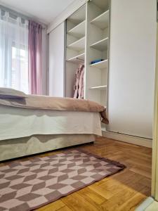 1 dormitorio con cama y alfombra a cuadros en Quiet Center en Sremska Mitrovica