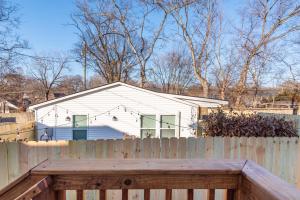 ein weißes Haus hinter einem Holzzaun mit einem Holzzaun in der Unterkunft Southbound Stays - Country Cottage in Nashville