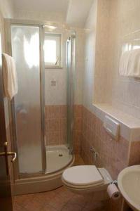 a bathroom with a shower and a toilet and a sink at ApartHotel Villa Mozart in Podgora