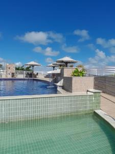 a swimming pool with umbrellas on top of a building at Sonia Flats Pipa's Bay - Flat 211 in Pipa