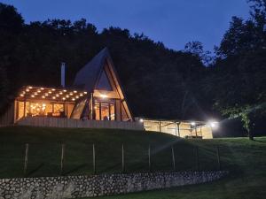 a house with a glass facade at night at Imanje Dedovina in Kosjeric
