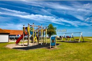 un parque infantil con toboganes y columpios en Seaview Park Premium Static Caravan Whitstable, en Whitstable