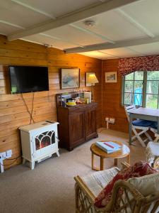 sala de estar con TV de pantalla plana y sofá en The Lodge On The Marsh en Brading