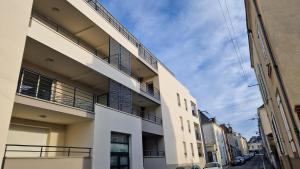 an apartment building with balconies on a street at Charmant T2 proche Gare in Laval