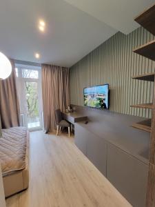 Czernowitz Deluxe Apartments في تشيرنيفتسي: غرفة معيشة كبيرة مع أريكة ومكتب