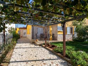 a stone pathway leading to a house with a pergola at Apartman Nik in Nova Vas