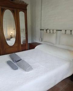 1 dormitorio con cama blanca y espejo en Don Alejandro en Córdoba