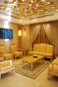 a living room with couches and a table and chairs at اجنحة المحمل للشقق الفندقية in Jeddah