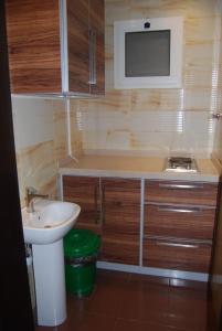 a small bathroom with a sink and a tv on the wall at اجنحة المحمل للشقق الفندقية in Jeddah