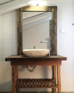 um lavatório de casa de banho com um espelho numa mesa de madeira em Antonis Studio em Lákka