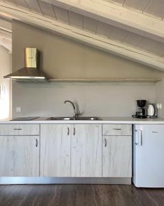 uma cozinha com armários de madeira e um lavatório em Antonis Studio em Lákka