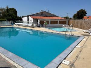 a large blue swimming pool in a yard at Mobil Home à Meschers au camping l'Escale proche de Royan in Meschers-sur-Gironde