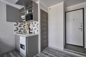 a kitchen with a white refrigerator and a door at Апарт 33 in Almaty