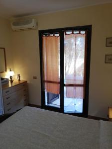 een slaapkamer met een bed en een groot raam bij Nico 12 in Santa Luria