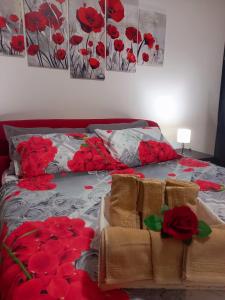 サンタ・ジュスタにあるAppartamento Fronte Lagunaの赤い花が咲くベッド