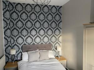 1 dormitorio con 1 cama con papel pintado en blanco y negro en Victorian South Belfast area Lisburn Road 3 Double Bedrooms - Great Transport Links en Belfast