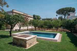 uma piscina num quintal com árvores e um edifício em Villa delle Zagare - private hydromassage pool em Surbo