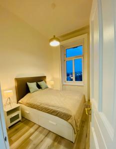Habitación pequeña con cama y ventana en Danube Panorama apartments en Budapest