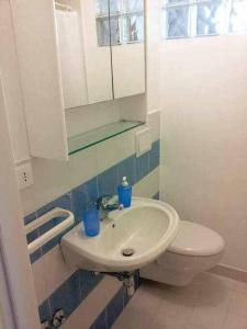een badkamer met een witte wastafel en een toilet bij Casa delle Palme sulla spiaggia in Marzamemi +16 foto's