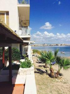 een gebouw op het strand met de oceaan op de achtergrond bij Casa delle Palme sulla spiaggia in Marzamemi