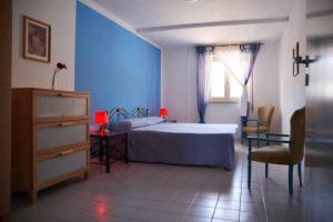 een blauwe slaapkamer met een bed en een raam bij Casa delle Palme sulla spiaggia in Marzamemi