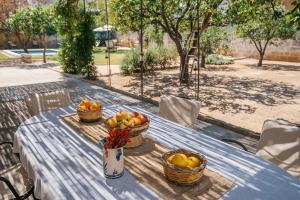 uma mesa de piquenique azul com cestos de fruta em Villa delle Zagare - private hydromassage pool em Surbo