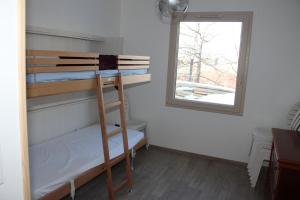 Pokój z łóżkiem piętrowym i oknem w obiekcie ANCELLE TAILLAS RDC CHALET w mieście Ancelle