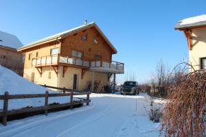 une maison dans la neige avec un camion garé dans l'allée dans l'établissement ANCELLE TAILLAS RDC CHALET, à Ancelle