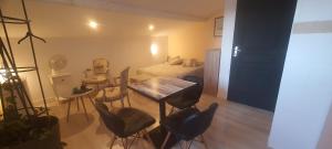Zimmer mit einem Tisch, Stühlen und einem Bett in der Unterkunft Chez Franck in Saint-Martin-de-Valgalgues