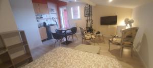 ein Wohnzimmer mit Stühlen und einem Tisch sowie eine Küche in der Unterkunft Chez Franck in Saint-Martin-de-Valgalgues