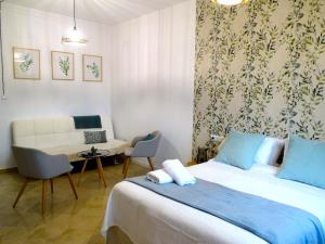 a bedroom with a bed and a couch and a table at Apartamentos Serrallo in Granada