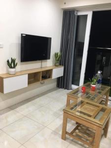 Una sala de estar con un televisor de pantalla plana en una pared. en New Life Tower B, Ha Long. Việt nam, en Ha Long