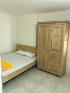 Un dormitorio con una cama y un armario de madera. en New Life Tower B, Ha Long. Việt nam, en Ha Long