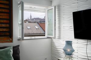 a living room with a window and a television at Nightingale Luxury Apartment in Budapest