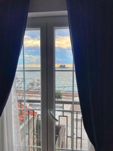 una ventana con vistas al océano desde una habitación en Lungomare Apartments, en Petrovac na Moru