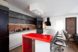 a kitchen with a red counter and some chairs at Nightingale Luxury Apartment in Budapest