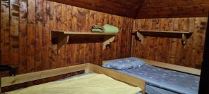 a room with a bed in a wooden cabin at Koča Pastirica - Velika planina in Stahovica