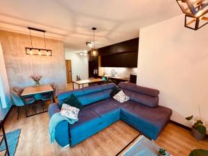 ギジツコにあるApartament Morsa w Nautica Resortのリビングルーム(青いソファ、テーブル付)