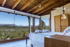 sypialnia z łóżkiem i dużym oknem w obiekcie BOG Dolce Far Niente w mieście Villa La Angostura