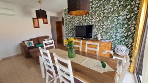a living room with a dining table and a television at Tirreno Vacances in San Juan de los Terreros