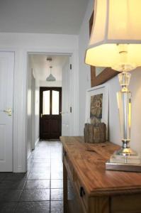 a hallway with a table with a lamp on it at Harbour View House in Ballycastle