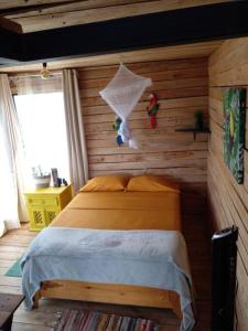 ein Schlafzimmer mit einem Bett in einer Holzwand in der Unterkunft Alto Luciérnaga 