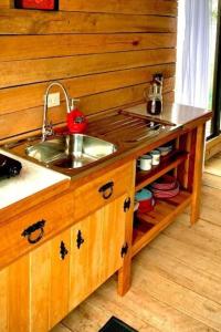 a kitchen with a sink and a wooden wall at Alto Luciérnaga 