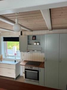 a kitchen with a sink and a stove top oven at The Cozy red house with Amazing sea view 