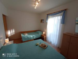 Apartment Milotić في لوفران: غرفة نوم صغيرة بسريرين ونافذة