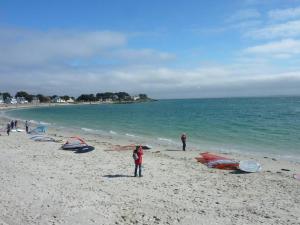grupa ludzi stojących na plaży z latawcami w obiekcie Maison 3 chambres 250 m de la mer w mieście Trinité-sur-Mer
