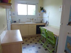 a kitchen with a counter and green chairs in it at Maison 3 chambres 250 m de la mer in La Trinité-sur-Mer