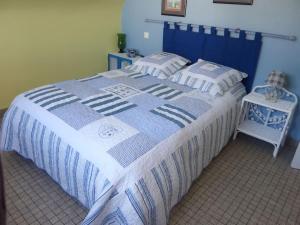 a blue and white bed with a blue and white blanket at Maison 3 chambres 250 m de la mer in La Trinité-sur-Mer